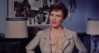 A woman with short brown hair wearing a jacket and a bow tie