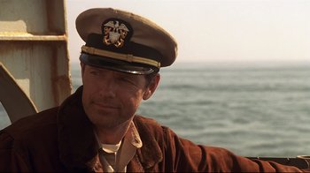 Movie still from “Below” (2002), directed by David Twohy – A man in a military uniform is looking into the distance; Close Up shot, Over the shoulder angle