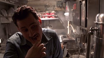 Movie still from “Below” (2002), directed by David Twohy – A man is eating something in a kitchen; Close Up shot, High angle