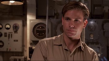 Movie still from “Below” (2002), directed by David Twohy – A man in a tan shirt is looking at the camera; Close Up shot, Over the shoulder angle