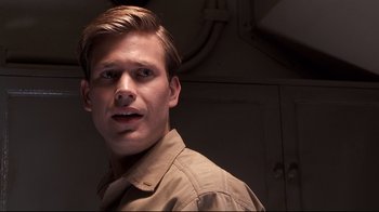 Movie still from “Below” (2002), directed by David Twohy – A man with a beard is looking at the camera; Close Up shot, Low angle