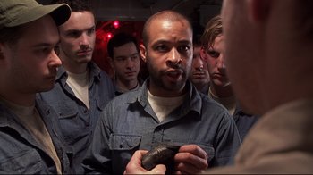 Movie still from “Below” (2002), directed by David Twohy – A group of men standing next to each other in a room; Close Up shot, High angle