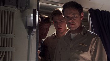 Movie still from “Below” (2002), directed by David Twohy – A group of men standing next to each other in a room; Medium shot, Low angle
