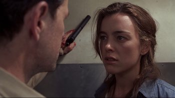 Movie still from “Below” (2002), directed by David Twohy – A man holding a hair brush over a woman's face; Close Up shot, Over the shoulder angle