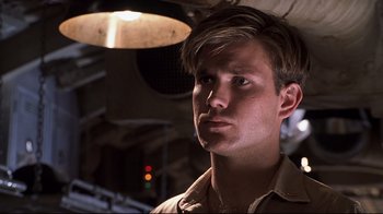 Movie still from “Below” (2002), directed by David Twohy – A young man with short brown hair is looking at the camera; Close Up shot, Low angle