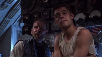 Movie still from “Below” (2002), directed by David Twohy – A man and a boy are posing for a picture; Medium shot, Low angle