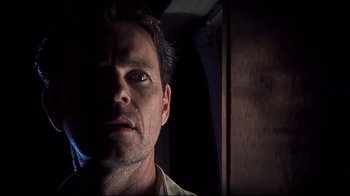 Movie still from “Below” (2002), directed by David Twohy – A person looking at the camera; Close Up shot, Low angle