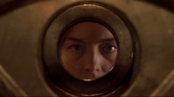 Movie still from “Below” (2002), directed by David Twohy – A woman looking into a round mirror with her eyes wide open; Extreme Close Up shot, Overhead angle