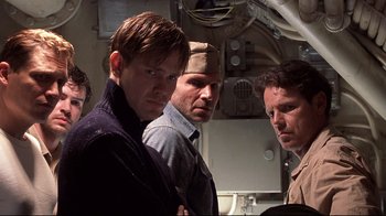 Movie still from “Below” (2002), directed by David Twohy – A group of men standing next to each other on a boat; Medium shot, Low angle