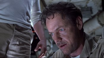 Movie still from “Below” (2002), directed by David Twohy – A person with a person in the background; Close Up shot, Low angle