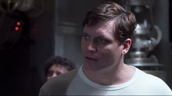 Movie still from “Below” (2002), directed by David Twohy – A person wearing a white t - shirt; Close Up shot, Low angle