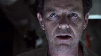 Movie still from “Below” (2002), directed by David Twohy – A man's face in the dark; Close Up shot, Low angle