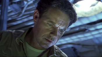 Movie still from “Below” (2002), directed by David Twohy – A person wearing a green shirt; Close Up shot, Low angle
