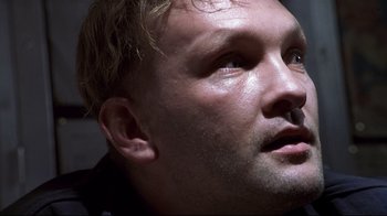 Movie still from “Below” (2002), directed by David Twohy – A man's face with a lot of light coming on; Close Up shot, Low angle