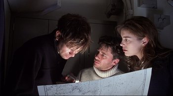 Movie still from “Below” (2002), directed by David Twohy – A group of people standing next to each other in a room; Medium shot, High angle
