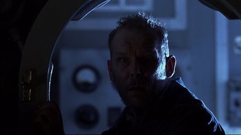 Movie still from “Below” (2002), directed by David Twohy – A person in a room with a light on; Close Up shot, Low angle