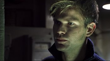 Movie still from “Below” (2002), directed by David Twohy – A person looking at the camera; Close Up shot, Low angle