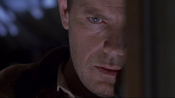 Movie still from “Below” (2002), directed by David Twohy – A man's face as he stares at the camera; Close Up shot, Low angle