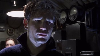 Movie still from “Below” (2002), directed by David Twohy – A young man is looking into the camera; Close Up shot, Low angle