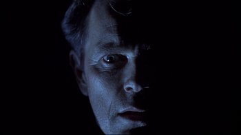 Movie still from “Below” (2002), directed by David Twohy – A man's face in the dark; Close Up shot, Low angle