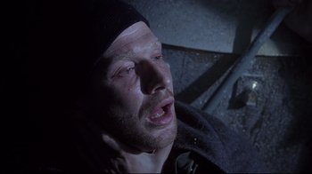 Movie still from “Below” (2002), directed by David Twohy – A person laying on the ground; Close Up shot, Overhead angle