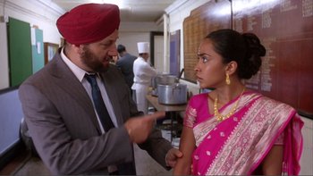 A man and a woman talking in a kitchen