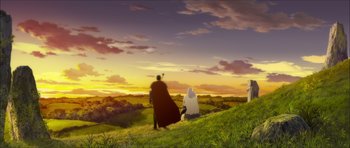 A couple of people sitting on top of a green hill