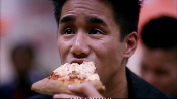Movie still from “Better Luck Tomorrow” (2002), directed by Justin Lin – A man eating a piece of pizza while wearing a black shirt; Extreme Close Up shot, High angle