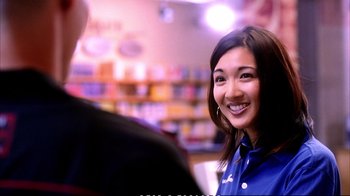 Movie still from “Better Luck Tomorrow” (2002), directed by Justin Lin – A young woman smiles brightly at the camera in a store; Close Up shot, Over the shoulder angle