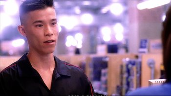 Movie still from “Better Luck Tomorrow” (2002), directed by Justin Lin – A man in a black shirt is standing in a store; Close Up shot, Over the shoulder angle
