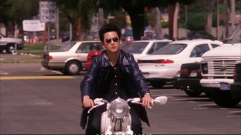 Movie still from “Better Luck Tomorrow” (2002), directed by Justin Lin – A man riding on the back of a motorcycle; Medium shot, Low angle