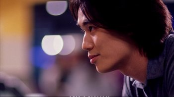 Movie still from “Better Luck Tomorrow” (2002), directed by Justin Lin – A young man's face with lights in the background; Close Up shot, Over the shoulder angle