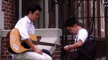 Movie still from “Better Luck Tomorrow” (2002), directed by Justin Lin – Two young men sitting on a bench with guitars; Medium shot, High angle