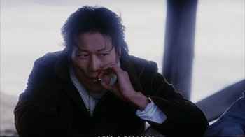 Movie still from “Better Luck Tomorrow” (2002), directed by Justin Lin – A man is talking on a cell phone while wearing a jacket; Close Up shot, Low angle