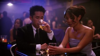 Movie still from “Better Luck Tomorrow” (2002), directed by Justin Lin – A man and a woman sitting at a table with drinks; Medium shot, High angle