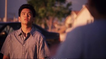 Movie still from “Better Luck Tomorrow” (2002), directed by Justin Lin – A young man standing in front of some trees; Close Up shot, Low angle