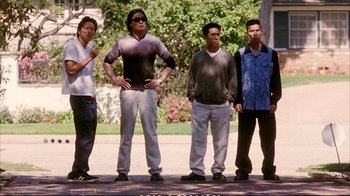 Movie still from “Better Luck Tomorrow” (2002), directed by Justin Lin – A group of young men standing next to each other on a sidewalk; Wide shot, Low angle