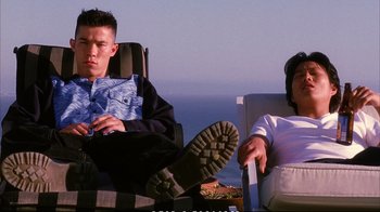 Movie still from “Better Luck Tomorrow” (2002), directed by Justin Lin – A man and a woman sitting on a chair next to each other; Medium shot, Low angle