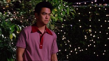 Movie still from “Better Luck Tomorrow” (2002), directed by Justin Lin – A man in a red and white shirt standing in front of a tree; Medium shot, Over the shoulder angle