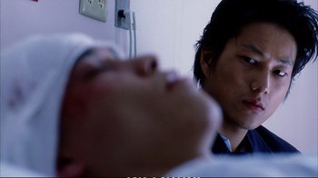 Movie still from “Better Luck Tomorrow” (2002), directed by Justin Lin – A man looking at another man laying on a bed; Close Up shot, Over the shoulder angle