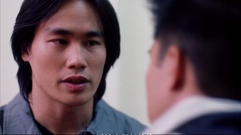 Movie still from “Better Luck Tomorrow” (2002), directed by Justin Lin – A man looking into a mirror while another man looks at him; Close Up shot, Over the shoulder angle