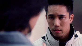 Movie still from “Better Luck Tomorrow” (2002), directed by Justin Lin – A man looking into a mirror while standing next to another man; Close Up shot, Over the shoulder angle