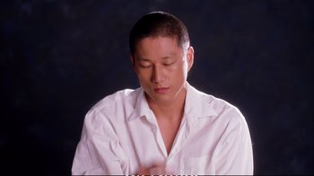 Movie still from “Better Luck Tomorrow” (2002), directed by Justin Lin – A man in a white dress shirt is sitting down; Close Up shot, High angle