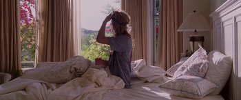 Movie still from “Beverly Hills Chihuahua” (2008), directed by Raja Gosnell – A woman sitting on top of a bed looking out a window; Medium shot, Over the shoulder angle