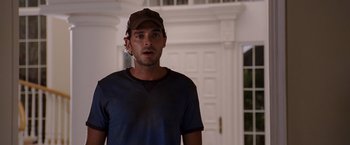 Movie still from “Beverly Hills Chihuahua” (2008), directed by Raja Gosnell – A man wearing a hat standing in front of a white door; Medium shot, Over the shoulder angle