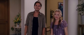 Movie still from “Beverly Hills Chihuahua” (2008), directed by Raja Gosnell – A man standing next to a woman in a room; Medium shot, Over the shoulder angle