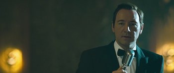 Movie still from “Beyond the Sea” (2004), directed by Kevin Spacey – A man in a suit and tie smoking a cigarette; Close Up shot, Low angle