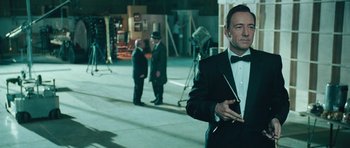 Movie still from “Beyond the Sea” (2004), directed by Kevin Spacey – A man in a tuxedo standing in front of other men; Medium shot, Over the shoulder angle