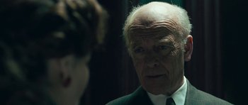 Movie still from “Beyond the Sea” (2004), directed by Kevin Spacey – An older man wearing a suit and tie looking at the camera; Close Up shot, Over the shoulder angle