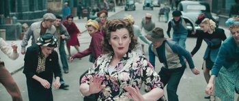 Movie still from “Beyond the Sea” (2004), directed by Kevin Spacey – An old photo of a woman in a floral dress; Medium shot, High angle